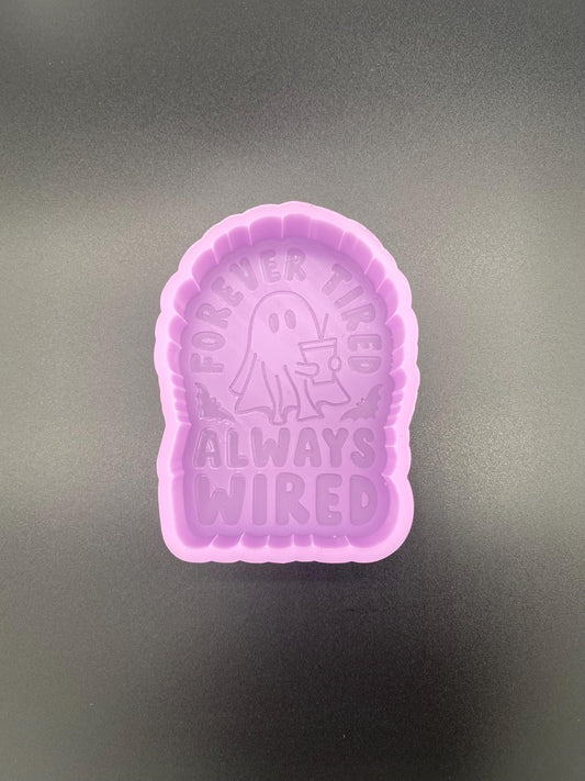 May include: A purple silicone mold with a ghost holding a cup and the text 'Forever Tired Always Wired'.